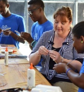 Stephanie learning to make beads for the Trades of Hope bracelets while in Haiti.